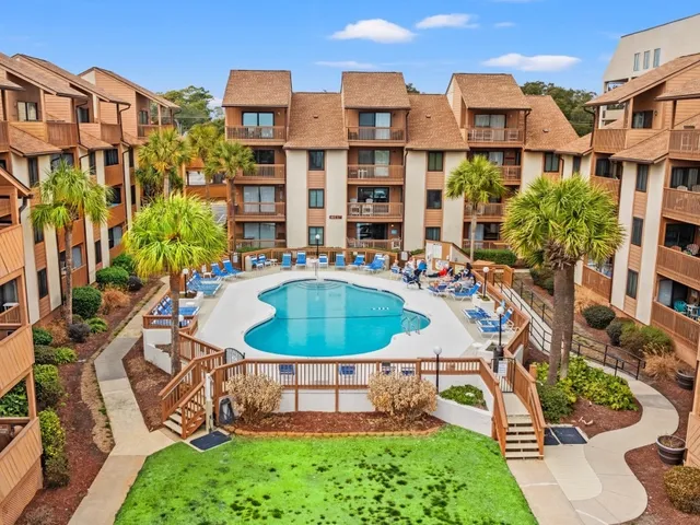 Landscaped lawn, garden beds and walkways at Anchorage, a Coastal-maintained Myrtle Beach community